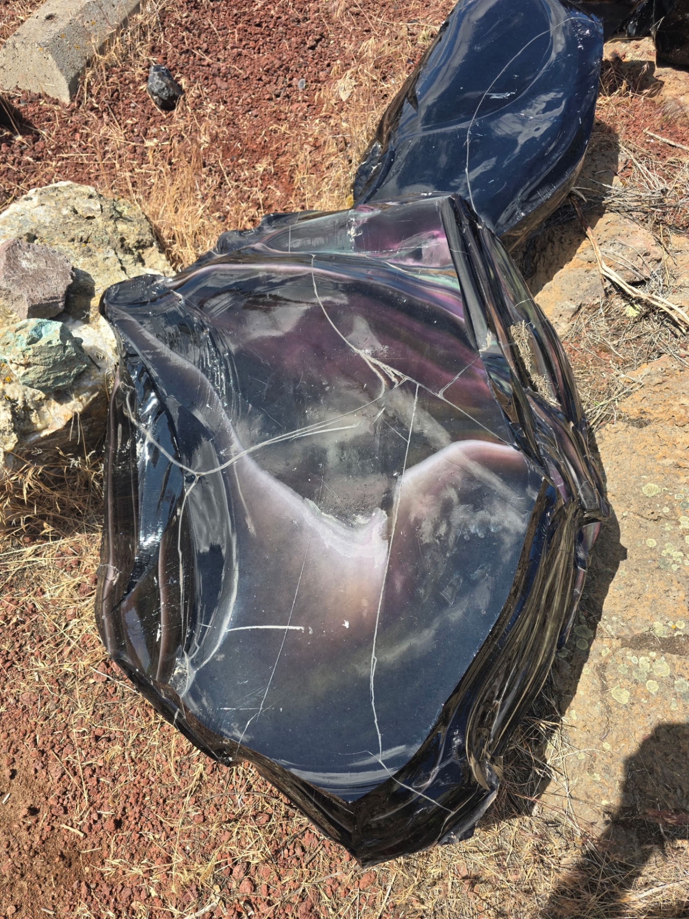 Rainbow obsidian boulder showing pink and violet sheen