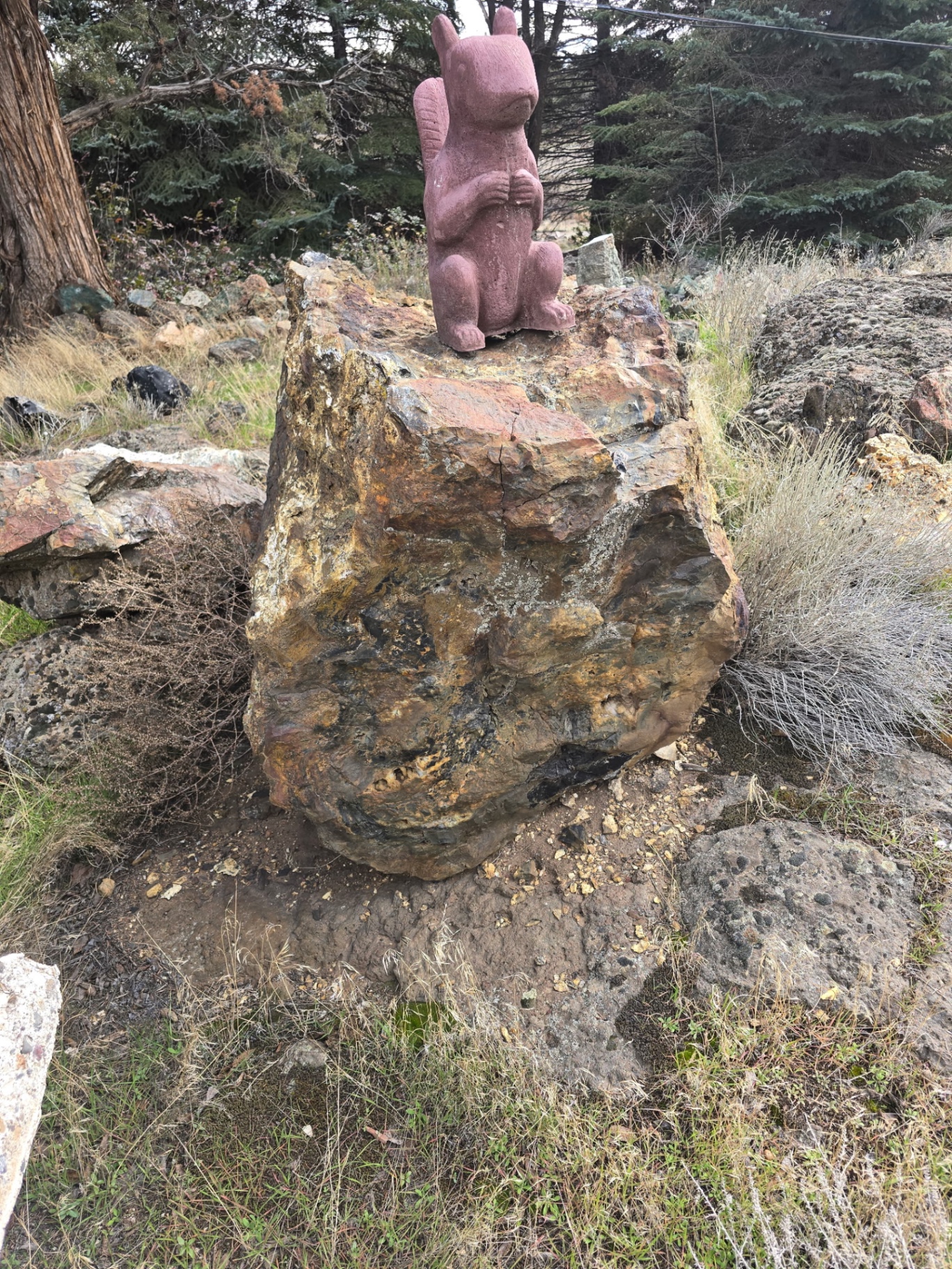 Stone sculpture displayed on a large rock at Madani Rock World